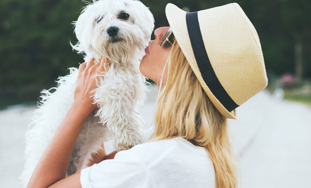 Woman kissing her dog