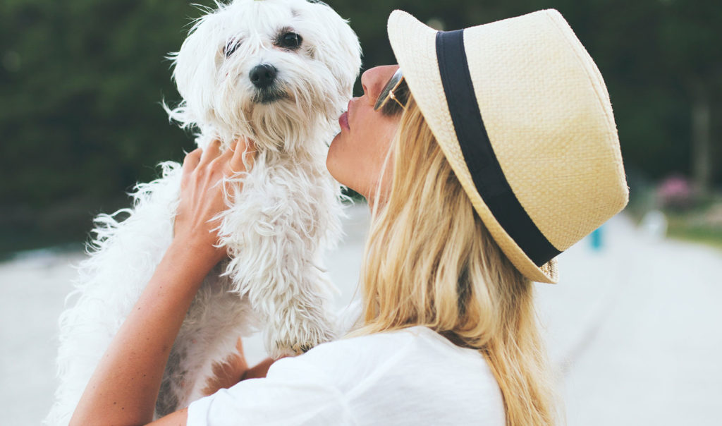 Woman kissing her dog